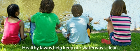 Children sitting in front of water. 