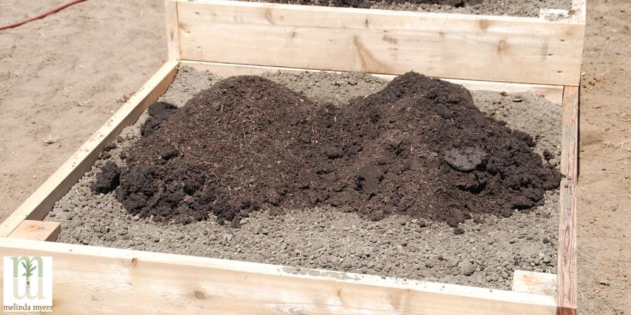garden topsoil poured into raised garden bed