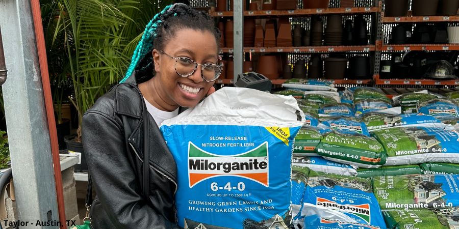 A Customer holding a bag of Milorganite Fertilizer in a garden center of a store.